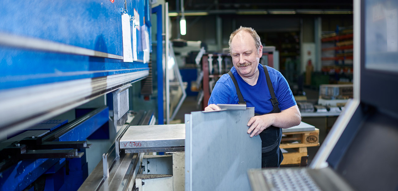 Elektror Mitarbeiter prüft bearbeitetes Blech