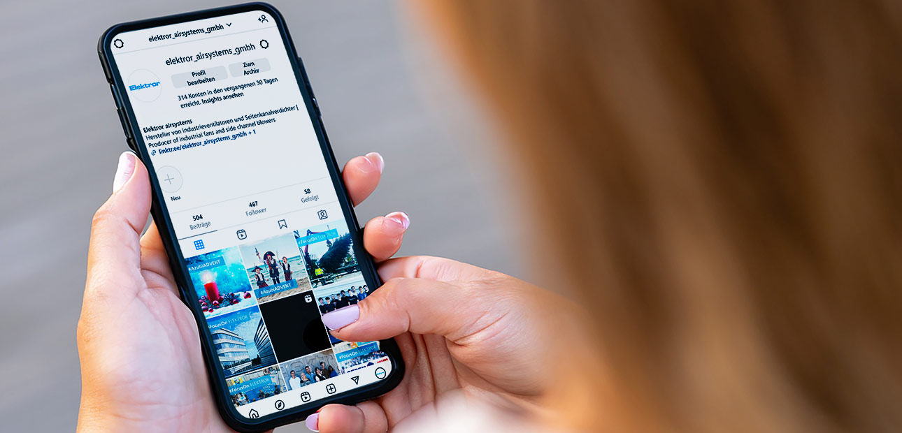 Person hält Smartphone in der Hand, das den Instagram-Kanal von Elektror zeigt. 